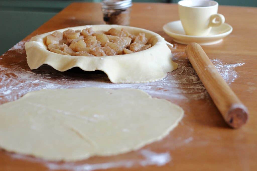 apple pie, with pastry, rolling pin on table 