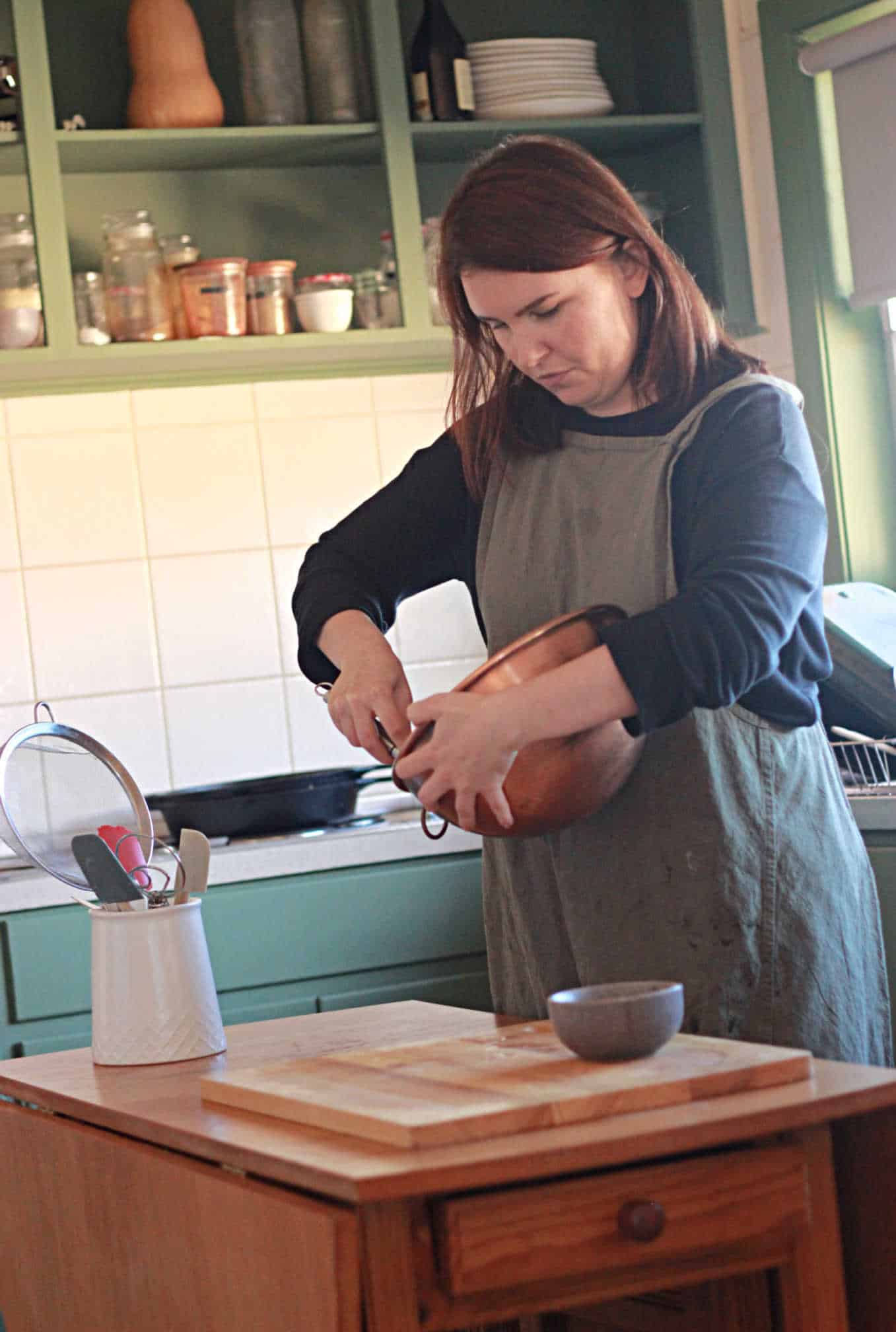 the simple mamma in the kitchen, holding a copper bowl