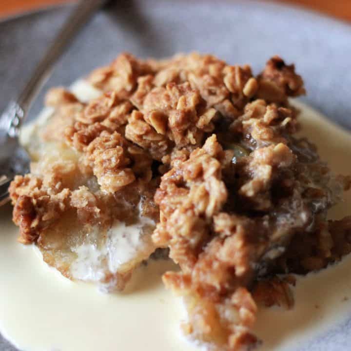 apple crumble and cream on plate with spoon, recipe card image
