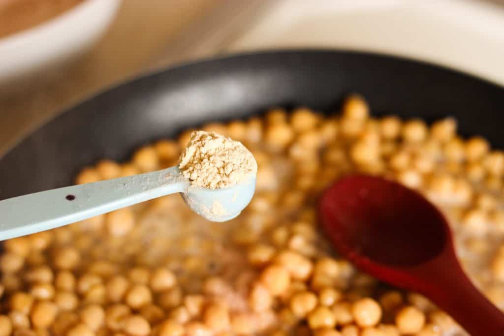 adding 1 tsp of garlic to the chickpeas in the pan 